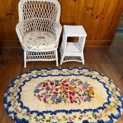 White Wicker Chair and Side Table with Vintage Floral Oval Rug 