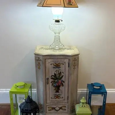Corner Cabinet with Painted Design, Glass Bass Lamp,  Battery Operated Lanterns 