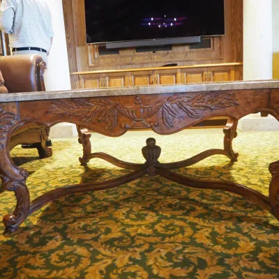 Sale Photo Thumbnail #97: Large statement coffee table featuring a shaped polished stone top over an extensively carved wood base with scrolling legs, leaf motifs, and decorative stretcher. Substantial construction and upscale traditional styling.