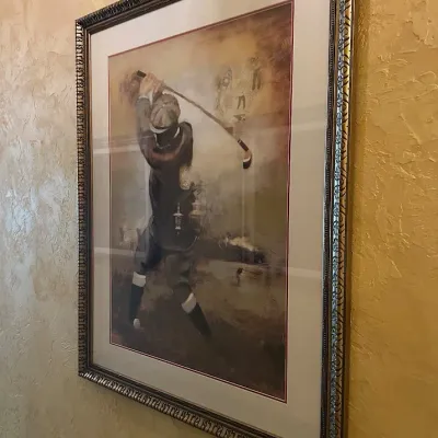 Sale Photo Thumbnail #76: You are bidding on a set of 4 items. Large framed golf artwork depicting a traditionally dressed early-era golfer with clubs and period-inspired graphic elements. Warm sepia and golden tones, professionally matted, and presented in an ornate antiqued fram