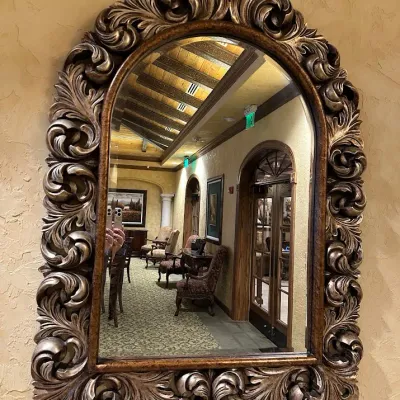 Sale Photo Thumbnail #116: Impressive oversized arched mirror surrounded by deeply sculpted acanthus and scroll detailing in an antiqued bronze/gold finish. A substantial statement mirror ideal for a foyer, powder room, dining room, or large entry wall.
