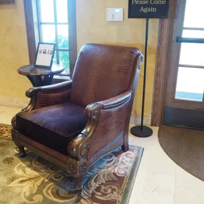 Sale Photo Thumbnail #101: Popular Designer Paul Robert traditional lounge chair featuring richly textured crocodile-embossed upholstery, oversized rolled and carved arms, decorative wood trim, and carved feet. Dramatic executive-club styling with visible character from previous us