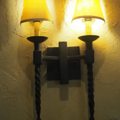Sale Photo Thumbnail #169: Matching pair of substantial Old World-style wall sconces featuring heavy dark-finished iron construction, two candle-style lights per fixture, twisted iron drop details and coordinating fabric shades. Strong Spanish Revival / Mediterranean / Tuscan styli