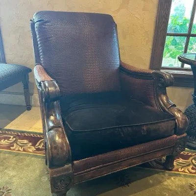 Sale Photo Thumbnail #100: Popular Designer Paul Robert traditional lounge chair featuring richly textured crocodile-embossed upholstery, oversized rolled and carved arms, decorative wood trim, and carved feet. Dramatic executive-club styling with visible character from previous us