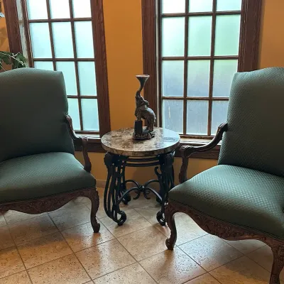 Sale Photo Thumbnail #131: You are bidding on the pair of handsome coordinating pair of high-back armchairs featuring muted green patterned upholstery, richly carved wood frames, shaped aprons, and cabriole-style legs. Substantial traditional clubhouse seating with an elegant Frenc