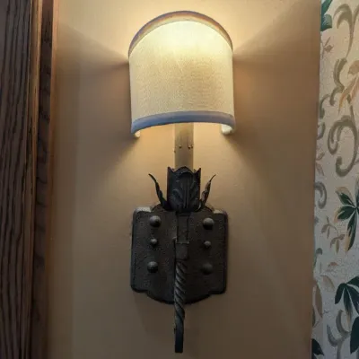 Sale Photo Thumbnail #8: Pair of rustic torch-style wall sconces with textured metal backplates, twisted stem detailing, decorative leaf accents, and small fabric shades. Well suited to traditional, Mediterranean, or Tuscan interiors.