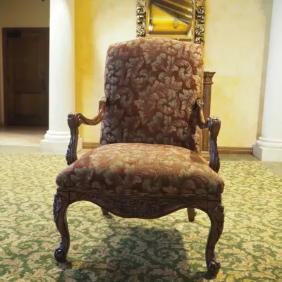 Sale Photo Thumbnail #109: Traditional high-back accent chair featuring richly patterned burgundy and muted green upholstery, carved wood arms, decorative apron, and cabriole-style legs. Substantial decorator-quality chair with classic Old World styling.