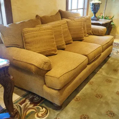 Sale Photo Thumbnail #143: Generously sized three-seat traditional sofa featuring neutral textured upholstery, oversized rolled arms, loose seat and back cushions, and coordinating paisley accent pillows. Substantial comfortable seating suitable for a family room, living room, or l