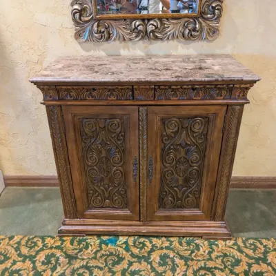 Sale Photo Thumbnail #32: Large traditional-style wood cabinet featuring deeply carved doors, decorative trim, upper drawers, and substantial molding throughout. Rich warm finish with an impressive architectural look. Ideal as a bar cabinet, storage cabinet, entry piece, or statem