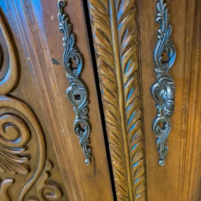 Sale Photo Thumbnail #37: Large traditional-style wood cabinet featuring deeply carved doors, decorative trim, upper drawers, and substantial molding throughout. Rich warm finish with an impressive architectural look. Ideal as a bar cabinet, storage cabinet, entry piece, or statem