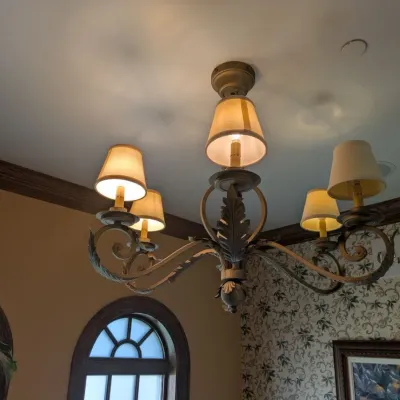 Sale Photo Thumbnail #88: Substantial traditional chandelier featuring scrolling metal arms, dimensional leaf detailing, and coordinating fabric shades. Antiqued bronze/gold finish with elegant Old World design. Buyer responsible for removal. Approx 38" round