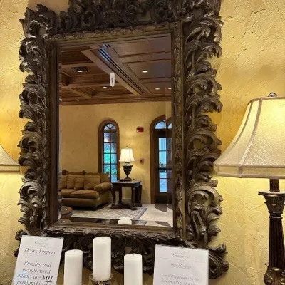 Sale Photo Thumbnail #117: Large formal wall mirror featuring an extensively carved Baroque-inspired frame with elaborate scrolling foliage and dramatic crest detail. Heavy, substantial statement piece formerly displayed above the clubhouse entry console. 41"w*58"h