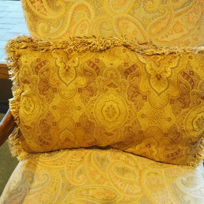 Sale Photo Thumbnail #135: High-back traditional armchair upholstered in a soft neutral paisley textile with carved wood arms, decorative apron, and cabriole-style legs. Attractive occasional chair with a more subdued palette than many of the clubhouse furnishings.