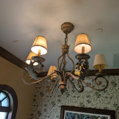 Sale Photo Thumbnail #89: Substantial traditional chandelier featuring scrolling metal arms, dimensional leaf detailing, and coordinating fabric shades. Antiqued bronze/gold finish with elegant Old World design. Buyer responsible for removal. Approx 38" round