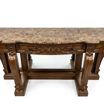 Sale Photo Thumbnail #46: Large ornate console or entry table featuring a stone or marble-style top, carved wood base, decorative drawer fronts, and substantial turned legs. Designed as a statement foyer piece and formerly used in an upscale clubhouse setting. 68"w*28"d*37"h