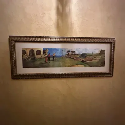 Sale Photo Thumbnail #81: Wide panoramic golf scene featuring golfers on a dramatic course surrounded by rugged landscape and architectural elements. Unusual horizontal format with professional matting and a substantial decorative frame. 65*26