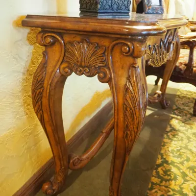 Sale Photo Thumbnail #153: Substantial traditional console table featuring extensive carved scroll and leaf detailing, shaped legs, and a decorative lower stretcher. Rich wood finish and architectural styling make this an attractive foyer, sofa, or hallway piece. 58"wx20"d*33.5h