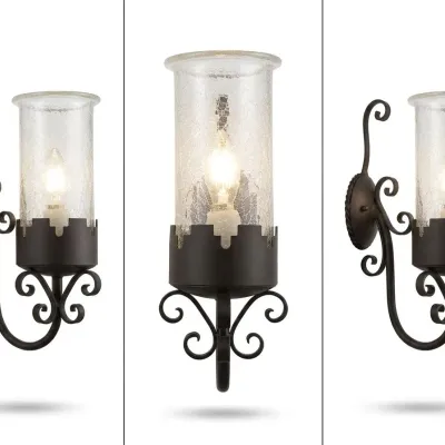 Sale Photo Thumbnail #5: Pair of traditional wall sconces featuring dark iron scrollwork and tall cylindrical crackle-glass shades. Old World styling with warm decorative light and substantial wall presence.