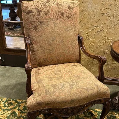 Sale Photo Thumbnail #134: High-back traditional armchair upholstered in a soft neutral paisley textile with carved wood arms, decorative apron, and cabriole-style legs. Attractive occasional chair with a more subdued palette than many of the clubhouse furnishings.