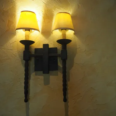 Sale Photo Thumbnail #170: Matching pair of substantial Old World-style wall sconces featuring heavy dark-finished iron construction, two candle-style lights per fixture, twisted iron drop details and coordinating fabric shades. Strong Spanish Revival / Mediterranean / Tuscan styli