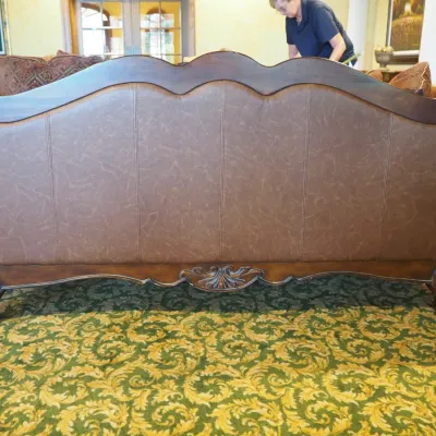 Sale Photo Thumbnail #106: Large traditional sofa upholstered in warm brown leather with oversized rolled arms, nailhead trim, carved wood base, and decorative scroll detailing. Includes coordinating oversized accent pillows and attractive aged character. 91w*38 deep* 41h