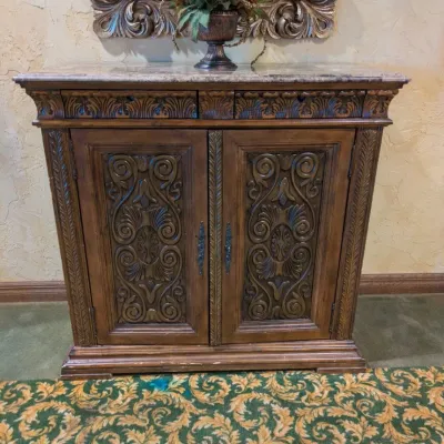 Sale Photo Thumbnail #35: Large traditional-style wood cabinet featuring deeply carved doors, decorative trim, upper drawers, and substantial molding throughout. Rich warm finish with an impressive architectural look. Ideal as a bar cabinet, storage cabinet, entry piece, or statem