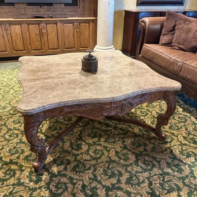 Sale Photo Thumbnail #96: Large statement coffee table featuring a shaped polished stone top over an extensively carved wood base with scrolling legs, leaf motifs, and decorative stretcher. Substantial construction and upscale traditional styling.