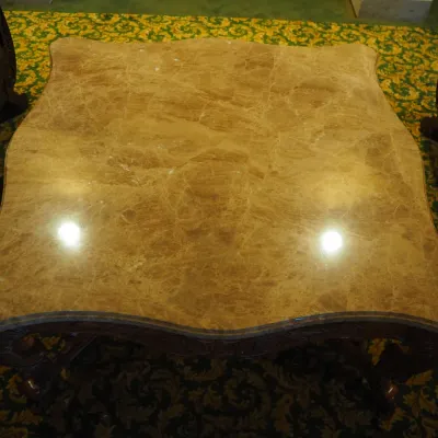 Sale Photo Thumbnail #98: Large statement coffee table featuring a shaped polished stone top over an extensively carved wood base with scrolling legs, leaf motifs, and decorative stretcher. Substantial construction and upscale traditional styling.