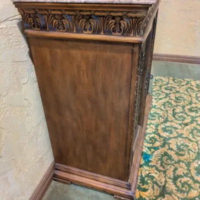 Sale Photo Thumbnail #36: Large traditional-style wood cabinet featuring deeply carved doors, decorative trim, upper drawers, and substantial molding throughout. Rich warm finish with an impressive architectural look. Ideal as a bar cabinet, storage cabinet, entry piece, or statem