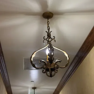 Sale Photo Thumbnail #10: Traditional hanging chandelier featuring ornate iron scrollwork and leaf-inspired detailing in an antiqued finish. A distinctive Old World fixture suitable for a hallway, foyer, or intimate dining area. Buyer responsible for removal.