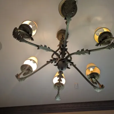 Sale Photo Thumbnail #90: Substantial traditional chandelier featuring scrolling metal arms, dimensional leaf detailing, and coordinating fabric shades. Antiqued bronze/gold finish with elegant Old World design. Buyer responsible for removal. Approx 38" round