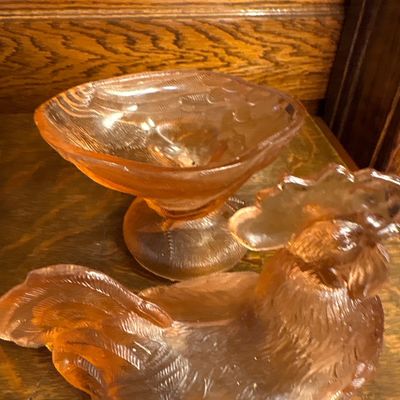 Sale Photo Thumbnail #680: vintage Westmoreland Pink Glass Rooster Covered Dish featuring a translucent peach-pink hue and a pedestal base, popular from the mid-century 1960s era.