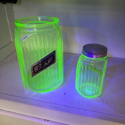 Sale Photo Thumbnail #725: This collection features vintage 1930s Anchor Hocking "Hoosier" ribbed green depression glass jars, made with uranium glass that glows brightly under a UV blacklight.