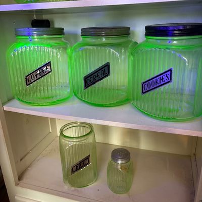Sale Photo Thumbnail #724: This collection features vintage 1930s Anchor Hocking "Hoosier" ribbed green depression glass jars, made with uranium glass that glows brightly under a UV blacklight.