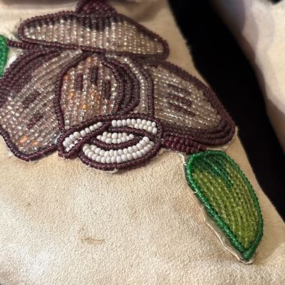 Sale Photo Thumbnail #73: Crafted from buckskin or tanned hide. Featuring folded high cuffs and beaded floral motif.