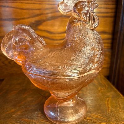 Sale Photo Thumbnail #676: vintage Westmoreland Pink Glass Rooster Covered Dish featuring a translucent peach-pink hue and a pedestal base, popular from the mid-century 1960s era.