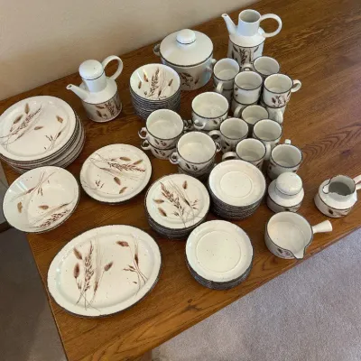 Sale Photo Thumbnail #127: This vintage Stonehenge Oven-To-Tableware set, named "Midwinter," by the Wedgwood Group England features a comprehensive collection of ceramic dining pieces including plates, cups, pitchers, and serving pots. The set is distinguished by its speckled off-w