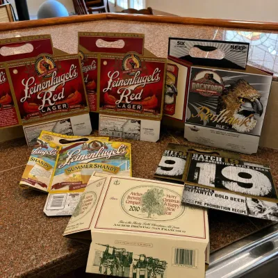 Sale Photo Thumbnail #291: This collection includes six assorted beer carriers showcasing unique branding from Leinenkugel's Red Lager and Summer Shandy, Rockyard's Redhawk Ale, Anchor Brewing Company with a 2010 Christmas and New Year design, and Batch 19 Pre-Prohibition Style Lag