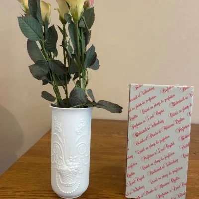 Sale Photo Thumbnail #25: This elegant decorative ceramic vase, crafted in Germany, features intricate raised patterns that add a touch of sophistication to any room. The vase is pure white, highlighting the detailed embossed floral and bead designs on its surface. Accompanied by 
