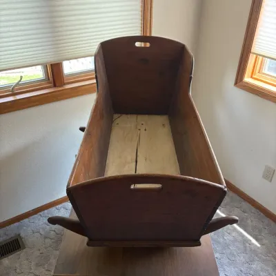 Sale Photo Thumbnail #22: This charming 19th century primitive wooden baby cradle is a beautiful example of traditional craftsmanship, featuring meticulously handcrafted dovetail joints that enhance its structural integrity and aesthetic appeal. Measuring 21 inches tall, 36 inches