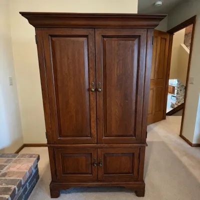 Sale Photo Thumbnail #177: This Lexington wood entertainment armoire offers sturdy construction and elegant design, perfect for housing your media equipment. Featuring a rich wood finish, it stands 65.5 inches tall, 36.5 inches wide, and 21.5 inches deep. The armoire includes multi