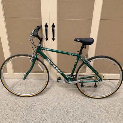 Sale Photo Thumbnail #204: This Cannondale H300 bike features a reliable 7-speed gear system, allowing for smooth and efficient riding across various terrains. It is equipped with a 42-inch frame size, ideally suited for comfortable handling and control. The bike sports a classic d