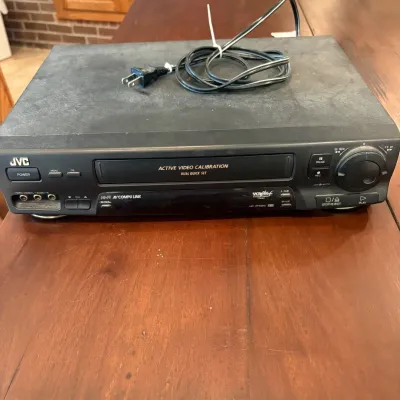 Sale Photo Thumbnail #67: This JVC HR-VP639U video cassette recorder is a classic piece of home entertainment equipment, designed for playing and recording VHS tapes. Featuring a sturdy black exterior, it includes front panel controls with play, stop/eject, rewind, fast forward, a