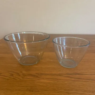 Sale Photo Thumbnail #257: This set includes two clear glass bowls, one larger and one smaller, perfect for various kitchen uses. The larger bowl measures approximately 8 inches in diameter and 5.5 inches in height, while the smaller bowl measures about 6.5 inches in diameter and 4