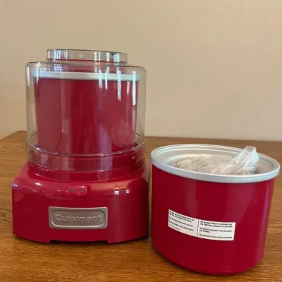 Sale Photo Thumbnail #235: This Cuisinart ice cream maker features a 1.5-quart capacity, perfect for homemade frozen desserts. It boasts a vibrant red color and compact design, measuring approximately 8 inches in height and width, making it a stylish and practical addition to any k