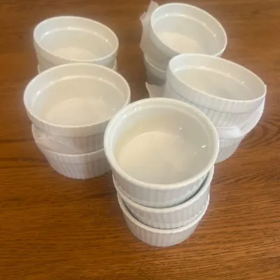 Sale Photo Thumbnail #263: This set includes 11 white ceramic soufflé dishes, perfect for baking and serving individual soufflés or other delicious desserts. Each dish features a classic fluted design and measures approximately 4.25 inches in diameter and 2.5 inches in height. Cr