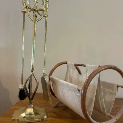 Sale Photo Thumbnail #155: This elegant fireplace essentials set includes a polished brass tool set featuring a shovel, brush, poker, and tongs with decorative handles, perfectly designed to maintain your hearth. Accompanied by a sturdy wooden frame log holder with natural-finish c