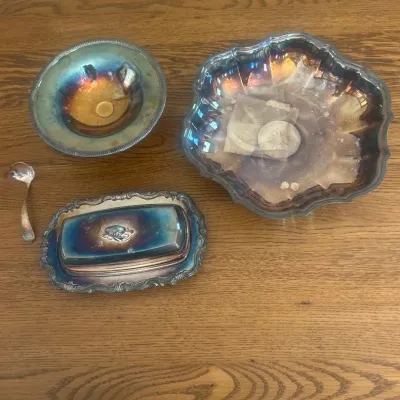 Sale Photo Thumbnail #148: This set includes four assorted silver-plated pieces featuring a beautiful iridescent finish with hints of blue and gold tones. The collection showcases various shapes including a scalloped bowl approximately 10 inches in diameter, a footed pedestal dish,