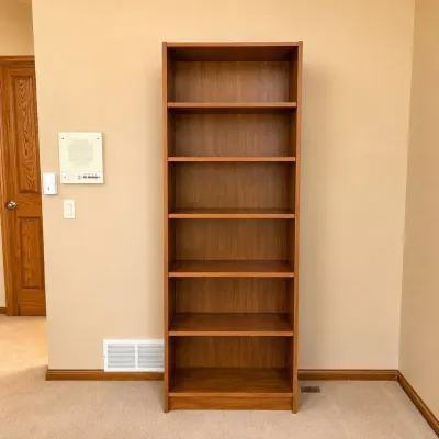 Sale Photo Thumbnail #183: This brown veneer bookcase combines practical storage with a sleek, minimalist design. Featuring a height of 78 inches, width of 24 inches, and depth of 12.5 inches, it fits comfortably in various room sizes. The rich brown veneer finish adds warmth and e