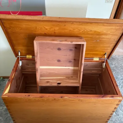 Sale Photo Thumbnail #76: This rustic wooden blanket chest offers a charming and functional storage solution, featuring distinct dovetail joinery that highlights the craftsmanship. The chest measures 28.5 inches tall, 44 inches wide, and 22 inches deep, providing ample space for b